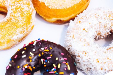 Çikolata kaplı, jöleli ve üzerine donut serpiştirilmiş bir fırın kutusunda çok renkli çörekler. Şeker bağımlılığı ya da festival menüsü konsepti.