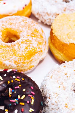 Çikolata kaplı, jöleli ve üzerine donut serpiştirilmiş bir fırın kutusunda çok renkli çörekler. Şeker bağımlılığı ya da festival menüsü konsepti.