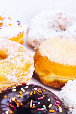 Çikolata kaplı, jöleli ve üzerine donut serpiştirilmiş bir fırın kutusunda çok renkli çörekler. Şeker bağımlılığı ya da festival menüsü konsepti.
