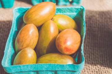 Tezgahın üzerinde kırmızı domates sepetleri var. Yerel çiftçi pazarında satışta. Organik, tarım ürünleri. Sağlıklı beslenmek için taze, mevsimlik sebzeler. Biyolojik vejetaryen yemekleri..
