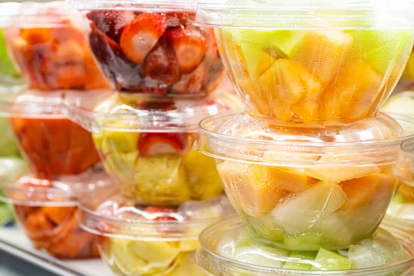 Fresh chopped fruits in plastic boxes in local store in USA. In-house cut and packed strawberries, blueberries, grapes, melon, pineapple to take away. Convenience, healthy lifestyle, food storage. ロイヤリティフリーのストック写真