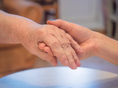 Yaşlı bir kadın eliyle tutan handyoung kadın el