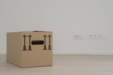 Düz duvar ve wodden döşeme boş odada üç kahverengi ambalaj kutuları