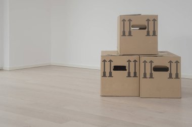 Düz duvar ve wodden döşeme boş odada üç kahverengi ambalaj kutuları