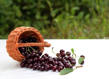 bir sepet kiraz doğa arka plan üzerinde beyaz bir masada duruyor