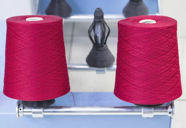 two coils of red yarn on the winding machine