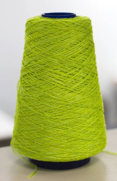 light green yarn in coils on machine in production