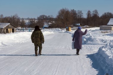 insanlar içinde belgili tanımlık kış karla kaplı bir yolda gider.