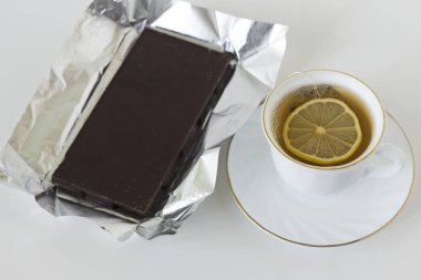 Bir fincan yeşil çay bir dilim limon ve karanlık koyu çikolata