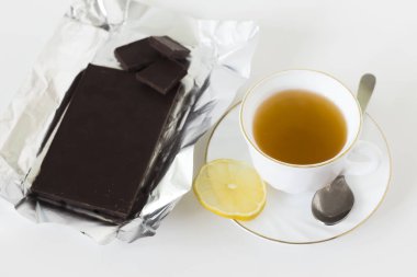 Bir fincan yeşil çay bir dilim limon ve karanlık koyu çikolata