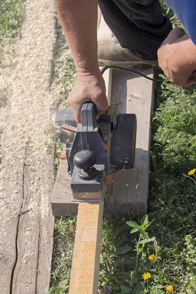 Tesař Funguje Elektrický Hoblík Dřevěném Prkénku Slunečného Dne Venku — Stock fotografie