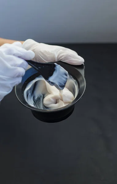 Peluquero Sostiene Tazón Tinte Para Cabello Sobre Fondo Negro Con —  Fotos de Stock