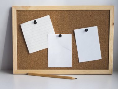 Üç boş resim kağıdım mantar pano ve basit bir kalem bağlı