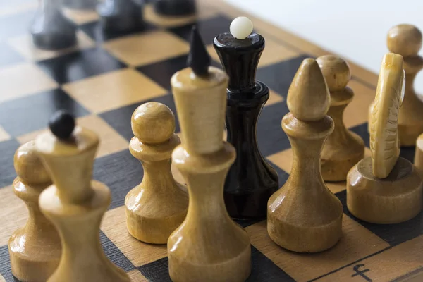 black Chess Queen with white chess pieces on the Board