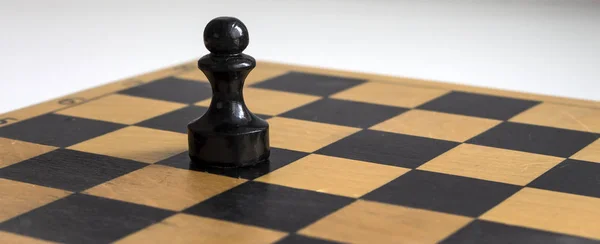 wooden black pawn on wooden Board