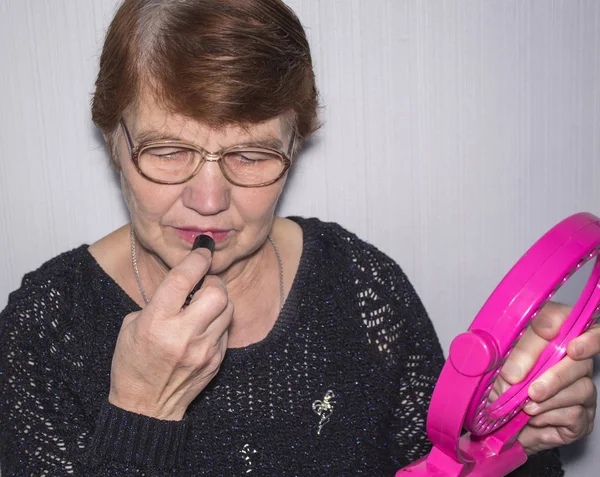 Elderly Woman Glasses Paints Her Lips Lipstick Holding Mirror Her — Stock Photo, Image