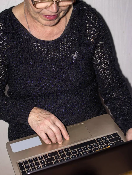 an elderly woman happy to keep the laptop presses the button