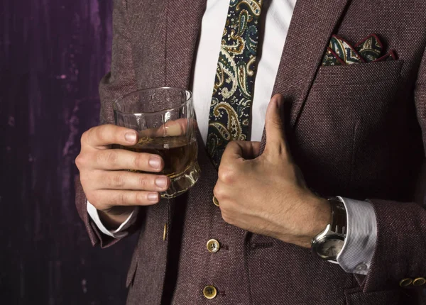 business man with whiskey in his hand shows a hand sign that everything is in order