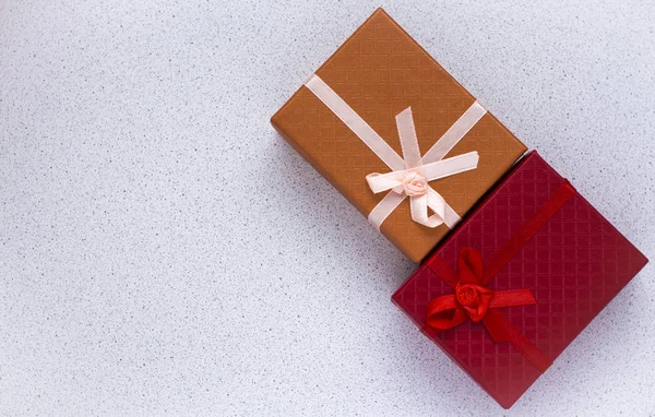 Due confezioni regalo in rosso e arancione, con fiocchi su sfondo bianco con spazio copia — Foto Stock