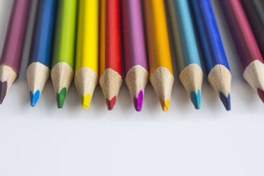 Renkli kalemler beyaz arkaplanda bir satırda yatıyor