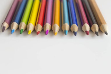 Üst üste bir gölge ile beyaz bir arka plan üzerinde renkli kalemler yalan