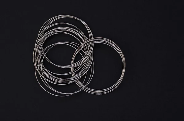 Jóias femininas, pulseiras de metal, sobre um fundo preto — Fotografia de Stock