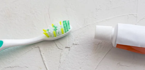 Toothbrush and toothpaste on white textured background — Stock Photo, Image