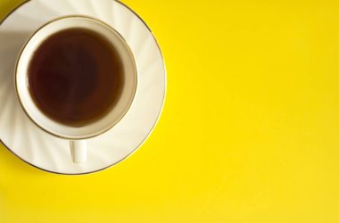 Bir fincan çay sarı bir arka plan üzerinde üstten görünüm görüntüsü. Daire yatıyordu. Kopya alanı