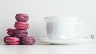 renkli macarons ve bir çay bardağı ile öğleden sonra çay tablo