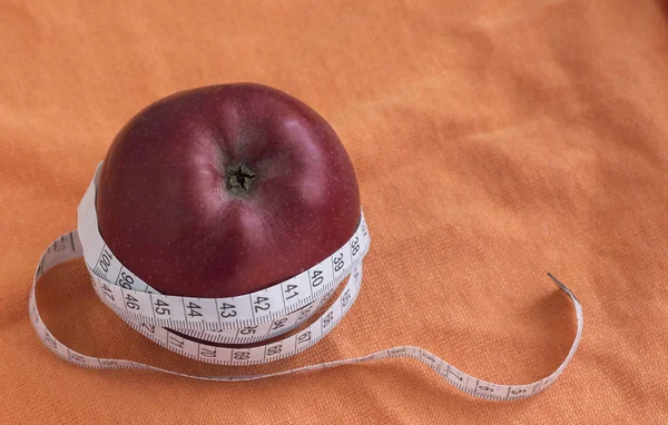 Conceito de dieta com Apple e fita métrica, em fundo laranja com espaço de cópia — Fotografia de Stock