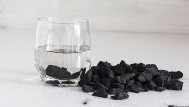 Russian shungite stones on a white background used in alternative medicine for water purification and recharge due to high carbon content and metaphysical properties clipart