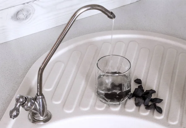 L'eau a traversé le filtre et avec des pierres de shungite, double purification de l'eau, amélioration de la santé — Photo