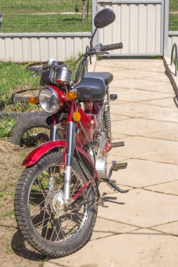 Moto scooter kırmızı bahçesinde ayakta