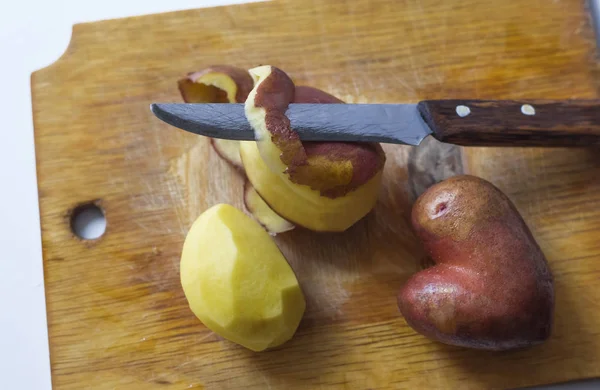 Fresh potatoes in the form of a heart on a cutting Board