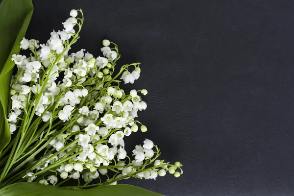 Boeket van witte lelies van de vallei op een donkere achtergrond met een kopie van de ruimte — Stockfoto