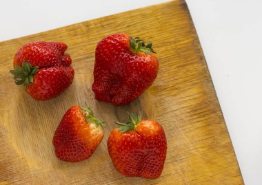 Olgun çilek bir kesme tahtasında bir satırda yerleştirilir