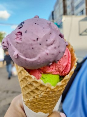 bir şehir sokakta bir adamın elinde renkli dondurma