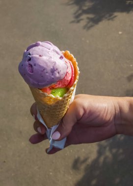 dondurma üç renk mor, yeşil ve kadınların ellerinde pembe