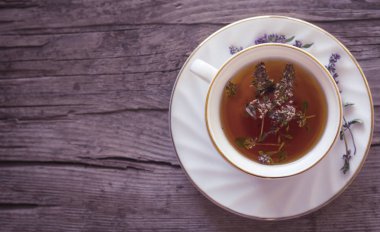 Eski bir ahşap arka planda taze vahşi kekli bir demet ile bitkisel çay. yukarıdan görünüm