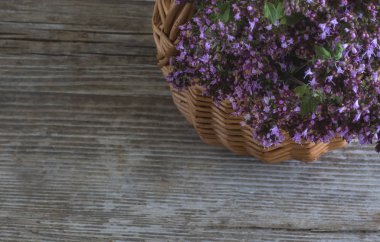 Alanın bir kopyası ile ahşap bir arka plan üst görünümünde bir sepet içinde kekik çiçek bir buket ile Kompozisyon