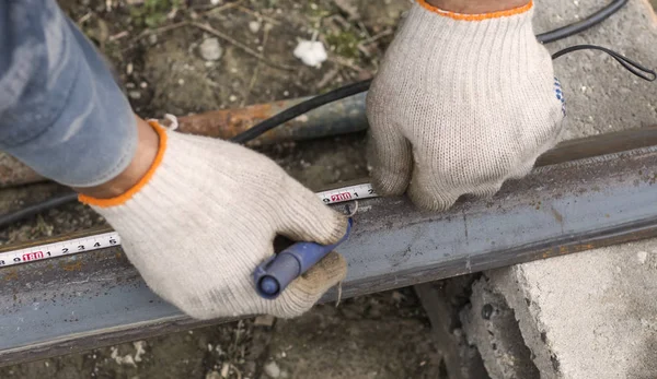Le soudeur effectue des mesures marqueur sur la poutre en acier pour un travail ultérieur — Photo