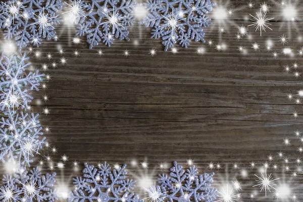 El concepto de las vacaciones de invierno, marco de copos de nieve sobre fondo de madera con espacio de copia — Foto de Stock