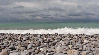 Azgın deniz , dalgalar kıyıya karşı dayak, gökyüzünde bulutlar.