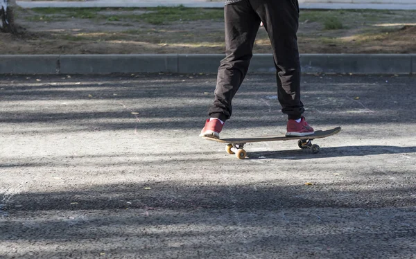 Un niño patinetas sobre el asfalto en tiempo soleado —  Fotos de Stock