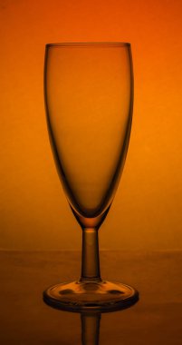 turuncu degrade üzerinde lümen üzerinde boş cam şampanya cam