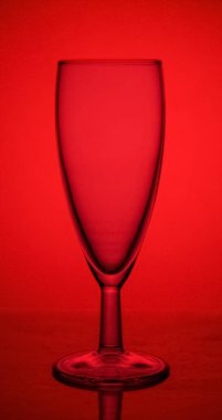 kırmızı bir arka plan üzerinde lümen üzerinde boş cam şampanya cam