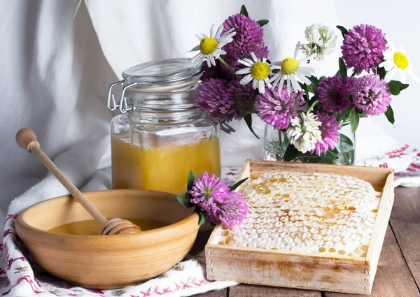 Νεκρή φύση με φρέσκο μέλι και λουλούδια σε υφαντό φόντο πετσέτας — Φωτογραφία Αρχείου