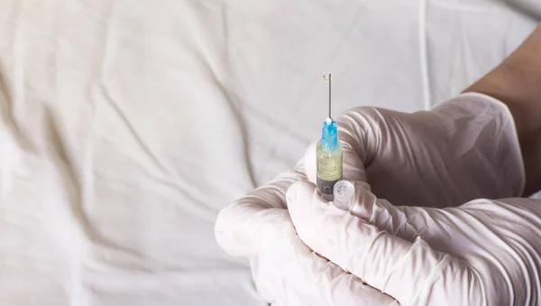 the nurse prepares for the injection by releasing air from the syringe with the medicine