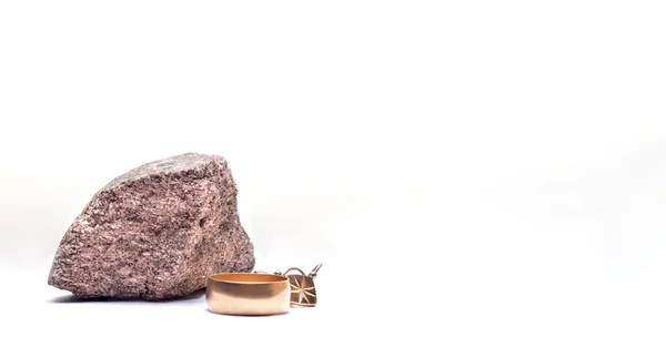 A piece of Gold ore with jewelry made of gold on a white background with a copy of the space — Stock Photo, Image