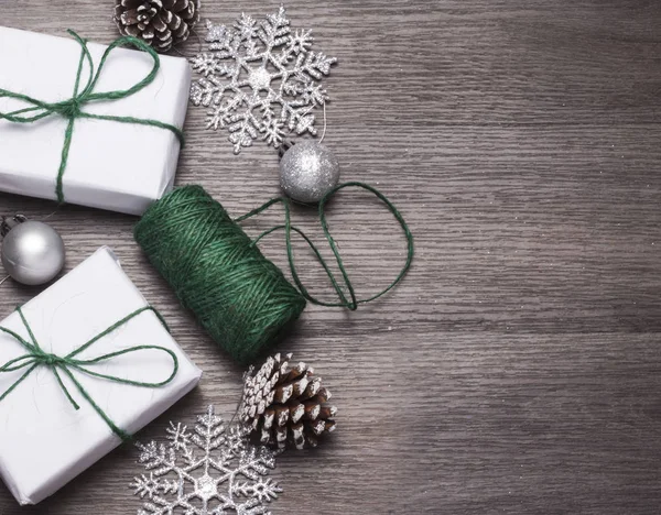 Deux cadeaux enveloppés dans du papier blanc attaché avec une corde verte pour Noël avec une copie de l'espace sur un fond de bois — Photo